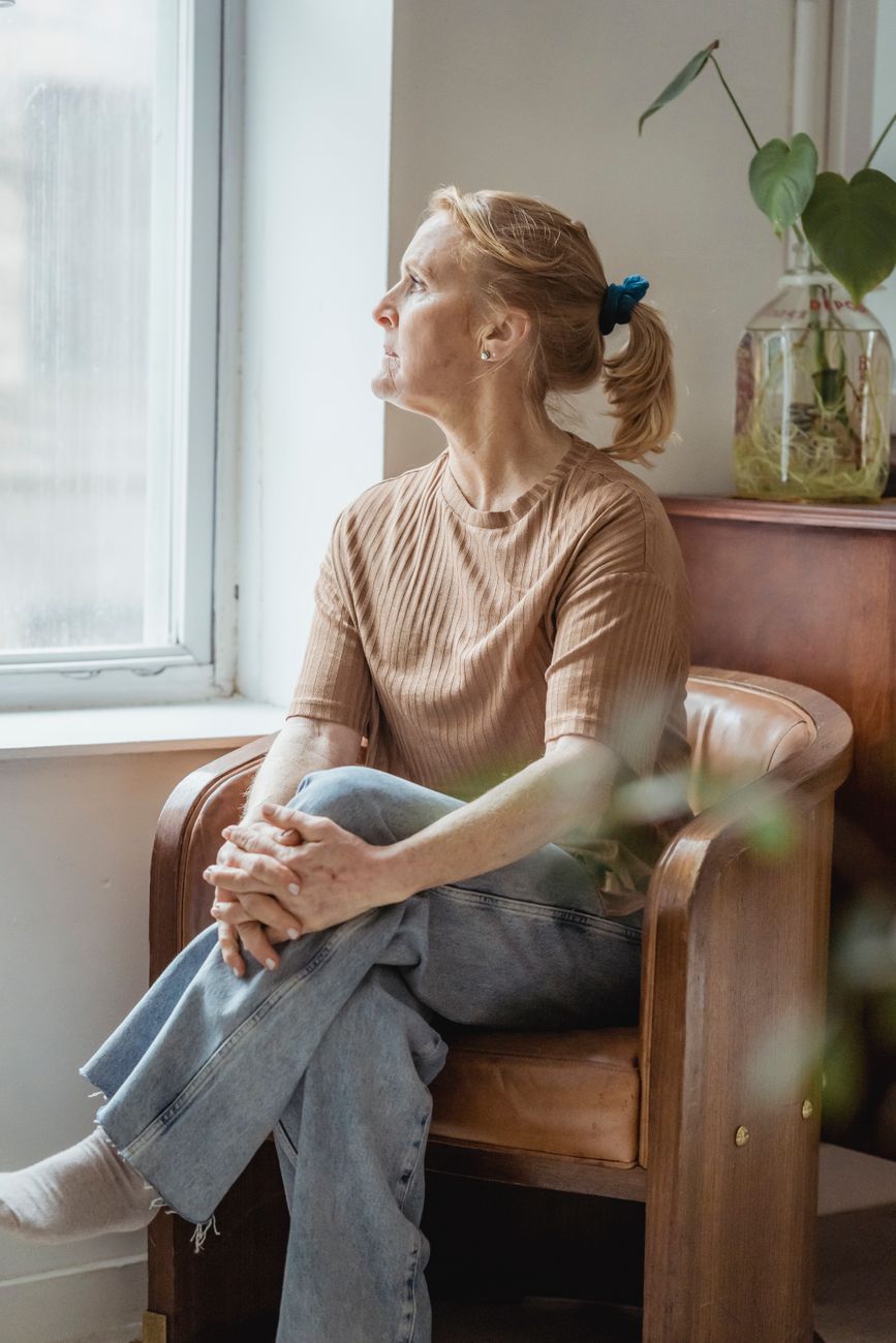 A woman in her fifties sitting quietly at home